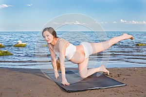 Pregnant woman in relaxation on yoga pose on sea