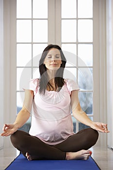 Pregnant Woman Relaxing With Yoga At Home