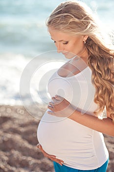 Pregnant woman resting at beach outdoors