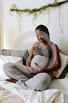 Pregnant woman resting on bed photo