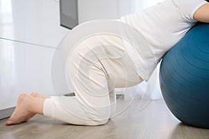 Pregnant woman resting on fitball during contractions at home