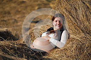 Pregnant woman resting on hay