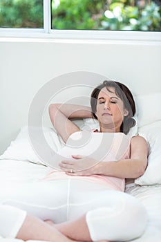 Pregnant woman resting on her bed