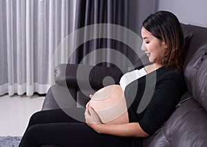 Pregnant woman resting at home on sofa