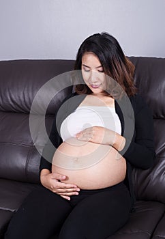 Pregnant woman resting at home on sofa