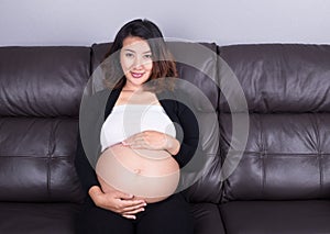 Pregnant woman resting at home on sofa