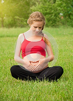 Pregnant woman is resting and relaxing on nature