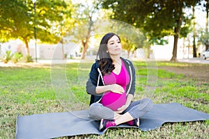 Pregnant woman resting on a yoga mat after her workout