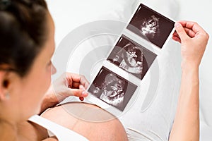 Pregnant woman reviewing baby ultrasound scan photo