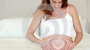 Pregnant woman rubbing cream on her belly