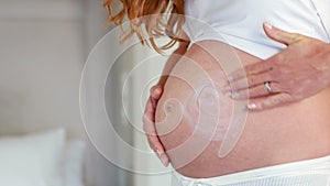 Pregnant woman rubbing cream on her belly