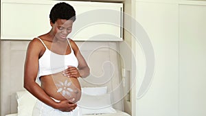 Pregnant woman rubbing cream on her belly