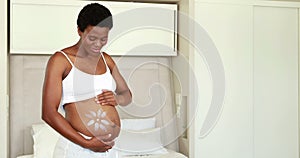 Pregnant woman rubbing cream on her belly