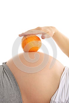 Pregnant woman's abdomen with orange