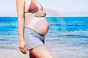 Pregnant woman on the sea beach.