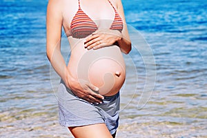 Pregnant woman on the sea beach.