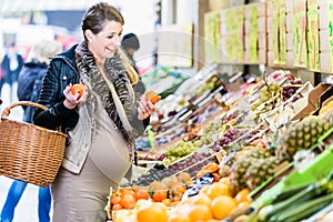 Pregnant woman shopping groceries on farmers market