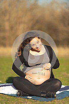 Pregnant woman showing belly with seven month mark