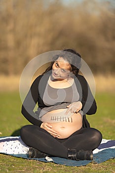 Pregnant woman showing belly with seven month mark