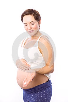 Pregnant woman showing body cream