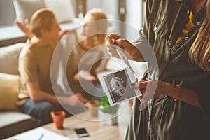 Pregnant woman showing evidence of her expectant state to couple