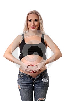 Pregnant woman showing heart symbol. Close up. White background