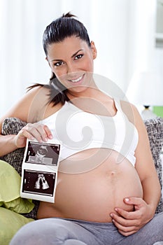 Pregnant woman showing ultrasound her baby