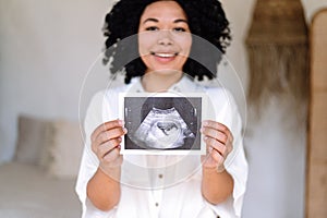 pregnant woman showing ultrasound photo her unborn baby