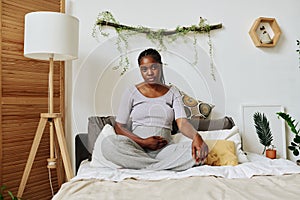 Pregnant woman sitting on bed photo