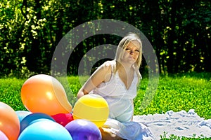 Pregnant woman sitting in colorful baloons