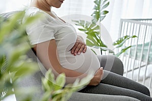 Pregnant woman sitting comfortably in the armchair