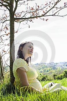 Pregnant Woman Sitting On Grass