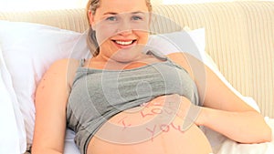 Pregnant woman sitting on her bed