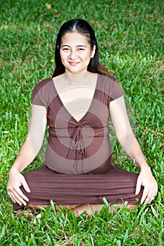 Pregnant woman sitting in the park . in anticipation of the chil