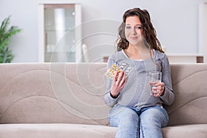 The pregnant woman sitting on sofa