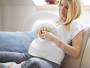 Pregnant woman sitting on sofa at home