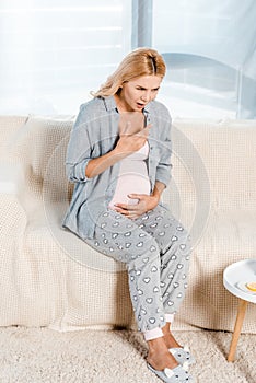 Pregnant woman sitting on sofa in living room