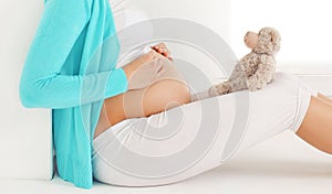 Pregnant woman sitting with teddy bear dreams of a future child