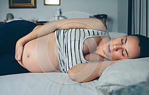 Pregnant woman sleeping in bed