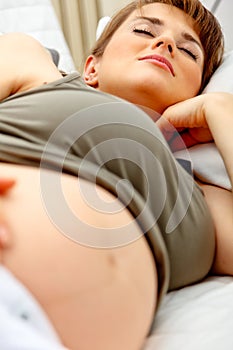 Pregnant woman sleeping on sofa at home