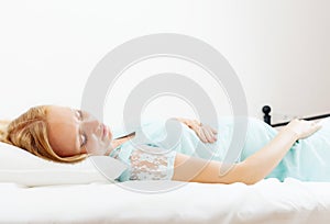 Pregnant woman sleeping on white pillow