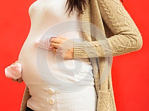 Pregnant woman with small shoes for unborn baby