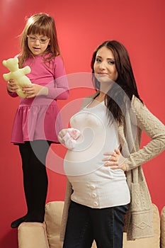 Pregnant woman with small shoes for unborn baby