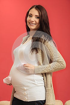 Pregnant woman with small shoes for unborn baby