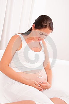 Pregnant woman with smile symbol on it