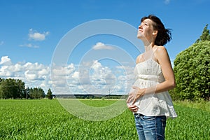 Pregnant woman smiling on field