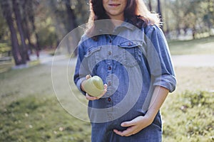 Pregnant woman snacking healthy with green apple