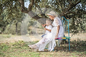 Pregnant woman spending time with her little son in the nature