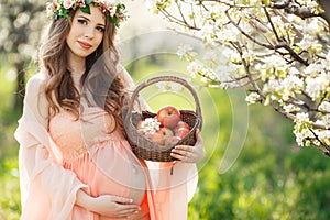 A pregnant woman in a spring garden with basket