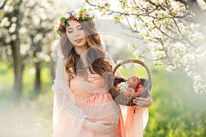 A pregnant woman in a spring garden with basket